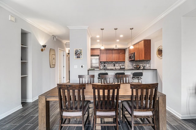 dining space with baseboards, wood finish floors, and ornamental molding