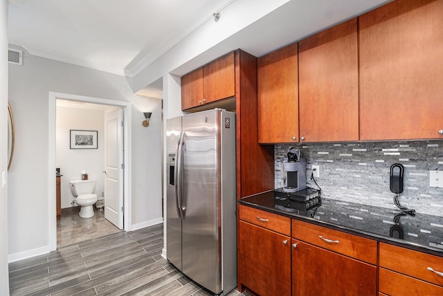 kitchen with visible vents, dark wood finished floors, stainless steel fridge with ice dispenser, crown molding, and decorative backsplash