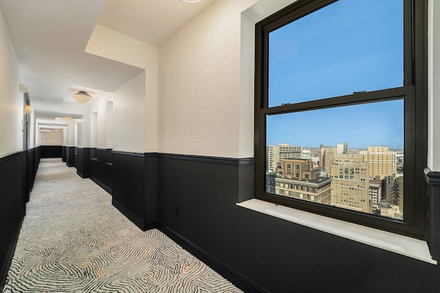 corridor with a wainscoted wall and a view of city