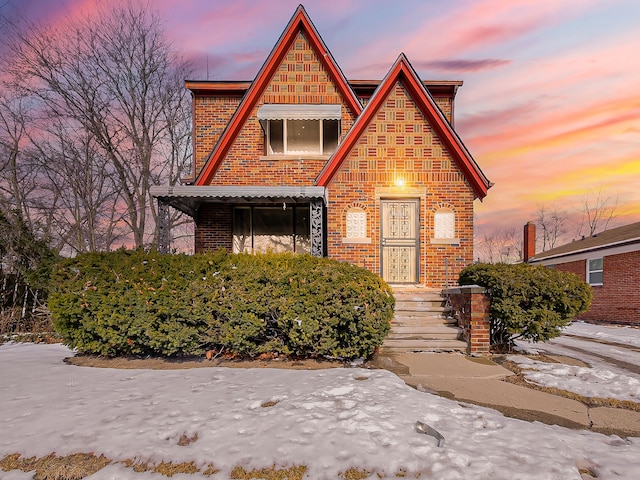 tudor house featuring brick siding