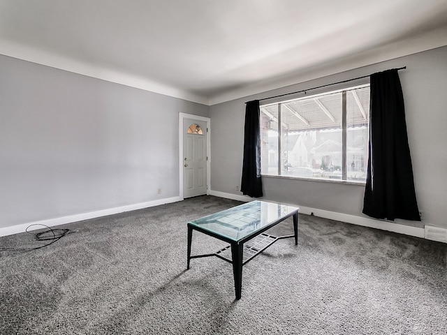 living area featuring carpet floors, visible vents, and baseboards