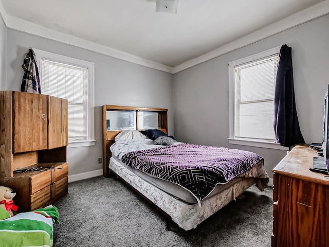 carpeted bedroom with multiple windows, baseboards, and crown molding