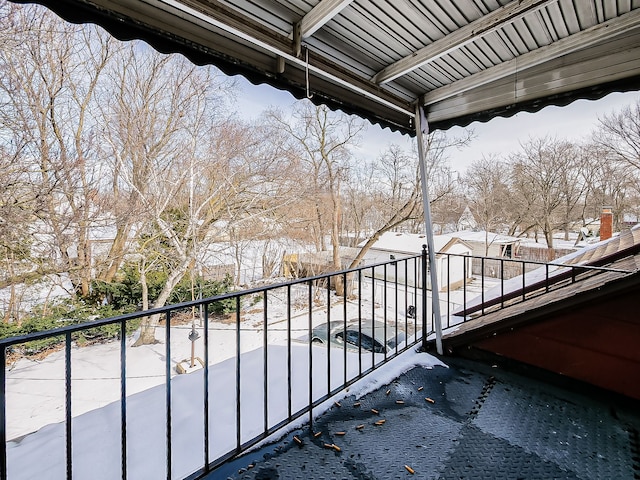 view of snow covered back of property