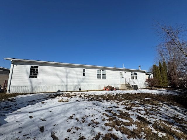 view of snow covered rear of property