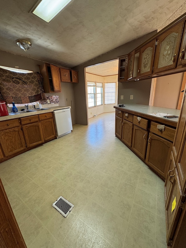 kitchen featuring light countertops, white dishwasher, visible vents, and light floors