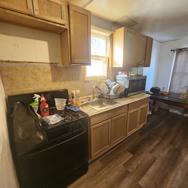 kitchen with light countertops, dark wood finished floors, stainless steel microwave, and a sink