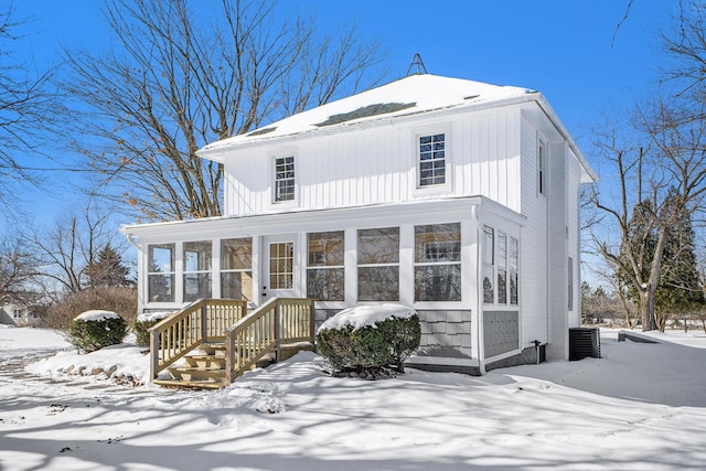 view of front of home with central AC unit and a sunroom