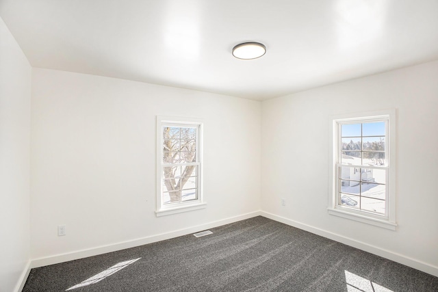 empty room featuring carpet, baseboards, and visible vents