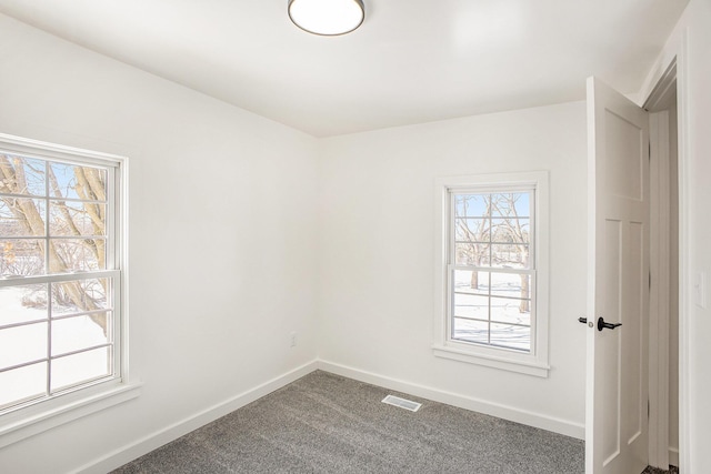 carpeted empty room with visible vents and baseboards