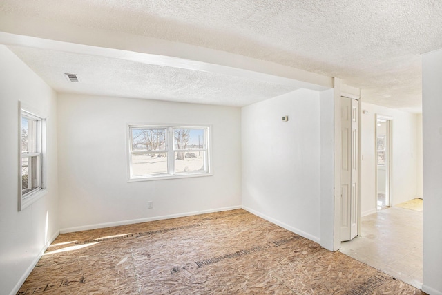 empty room with visible vents and a textured ceiling