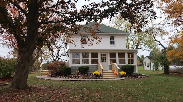 view of front facade with a sunroom and a front yard