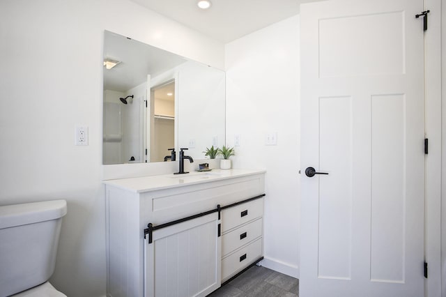 full bath featuring toilet, recessed lighting, and vanity