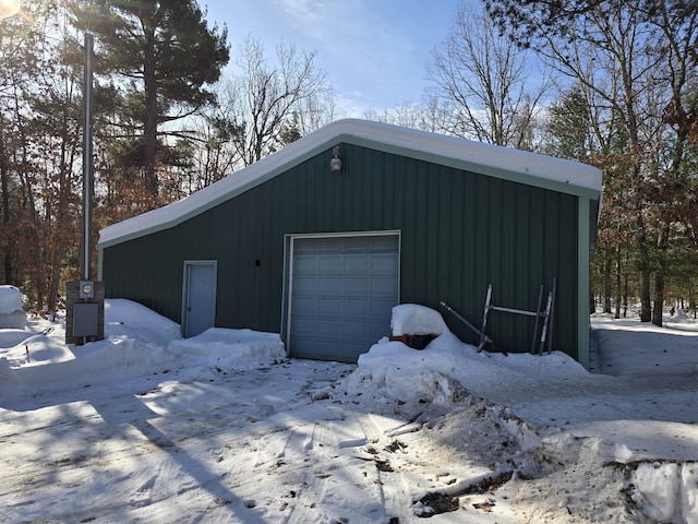 snow covered garage featuring a garage