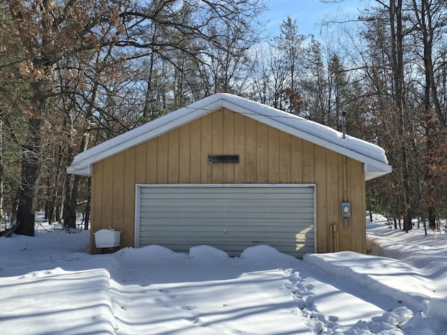 snow covered garage featuring a garage