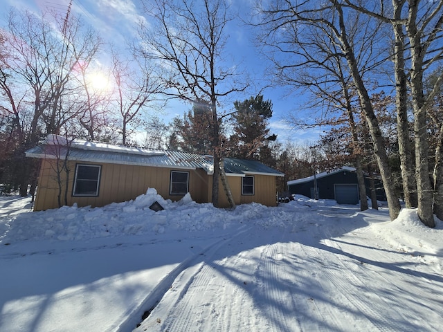 view of front facade featuring a detached garage and an outdoor structure