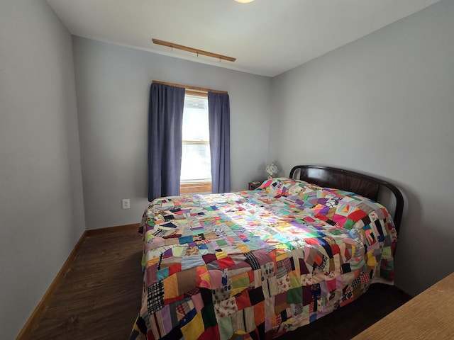 bedroom featuring dark wood-type flooring and baseboards