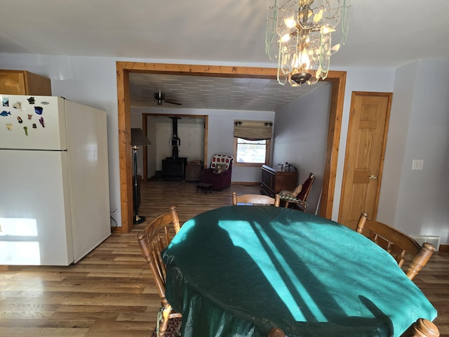 dining area featuring wood finished floors and a wood stove