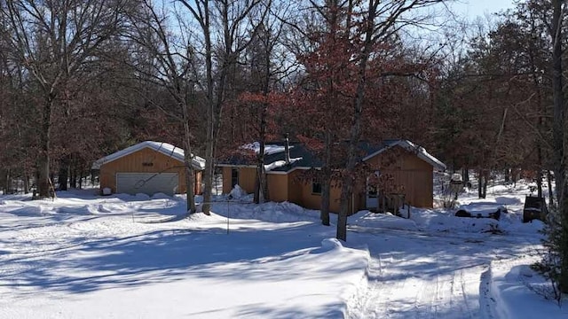 snowy yard featuring a garage