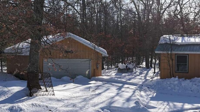 yard covered in snow with a detached garage and an outdoor structure