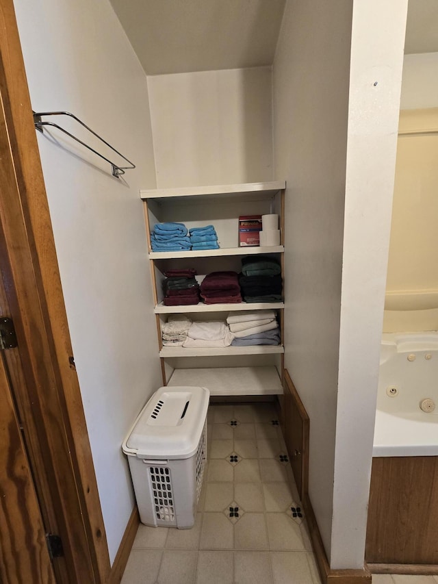 bathroom featuring a jetted tub, tile patterned flooring, and baseboards