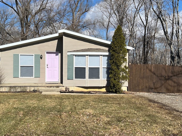 view of front facade with a front lawn and fence