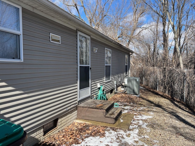 snow covered property with central AC and crawl space