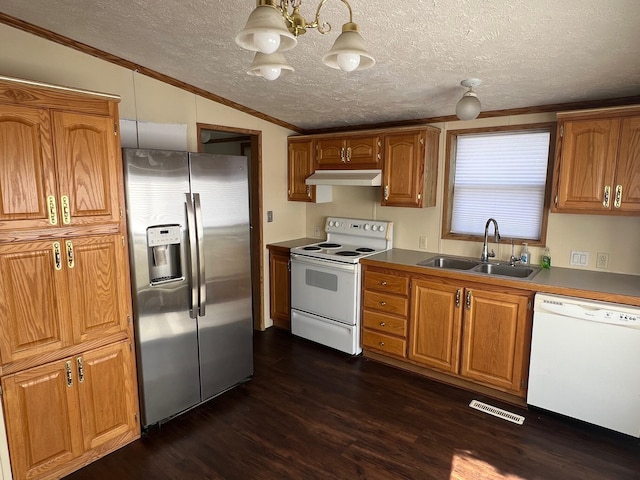 kitchen featuring vaulted ceiling, white appliances, brown cabinetry, and a sink