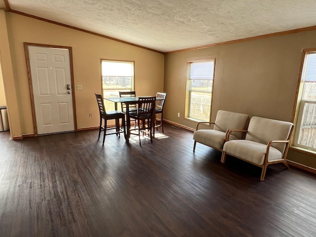 dining area featuring dark wood-style floors, ornamental molding, vaulted ceiling, and a textured ceiling