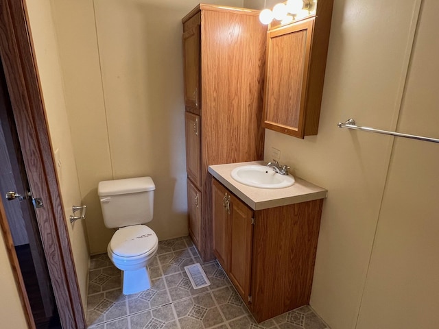 bathroom featuring toilet, tile patterned floors, visible vents, and vanity