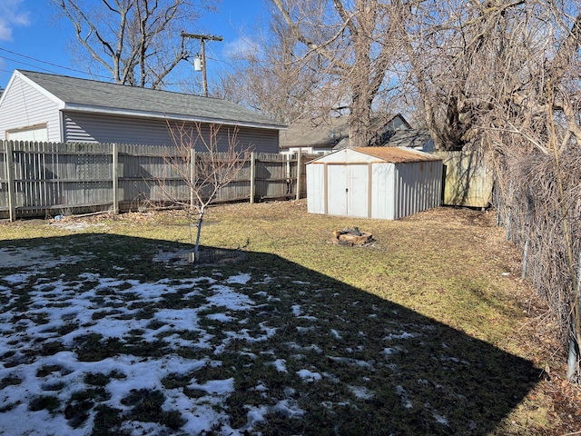 view of yard featuring a storage shed, a fenced backyard, and an outbuilding