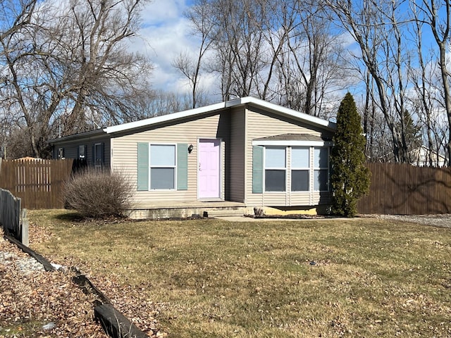 view of front of house with a front yard and fence