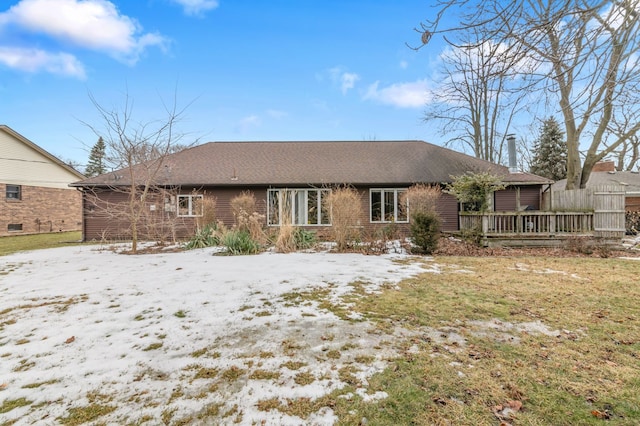 snow covered back of property featuring brick siding