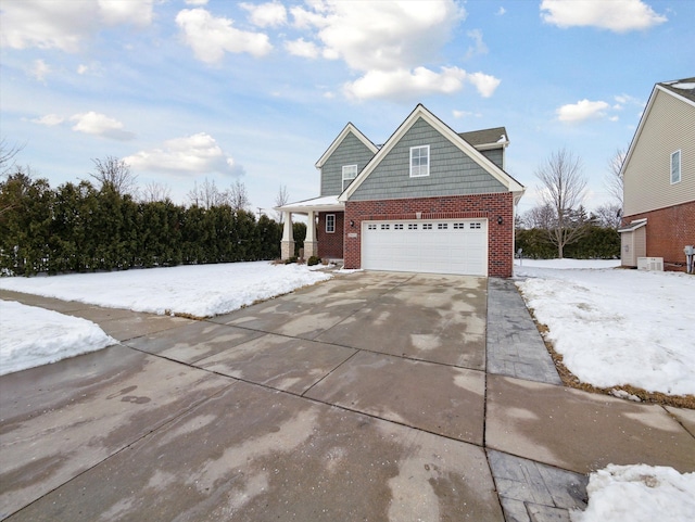 view of front of house featuring a garage, concrete driveway, and brick siding