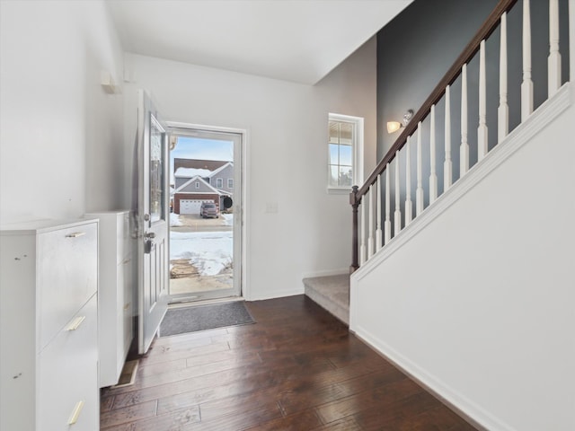 foyer with stairs, dark wood finished floors, and baseboards