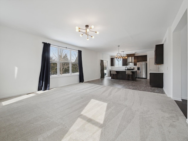 living room featuring baseboards, dark carpet, and an inviting chandelier