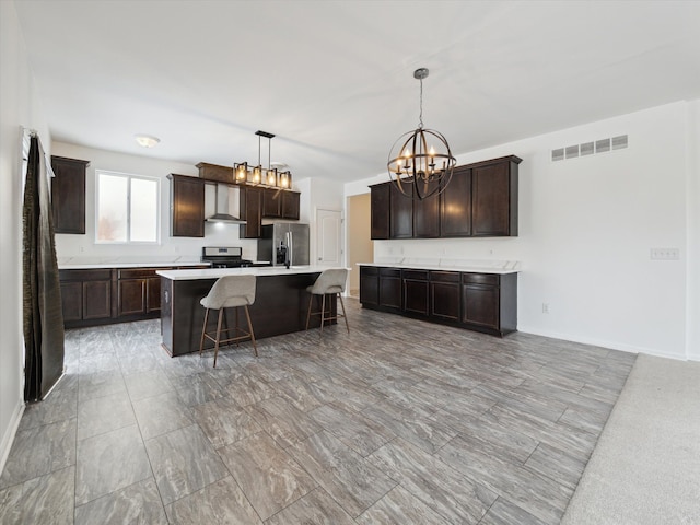 kitchen with dark brown cabinetry, visible vents, stainless steel appliances, and a kitchen breakfast bar