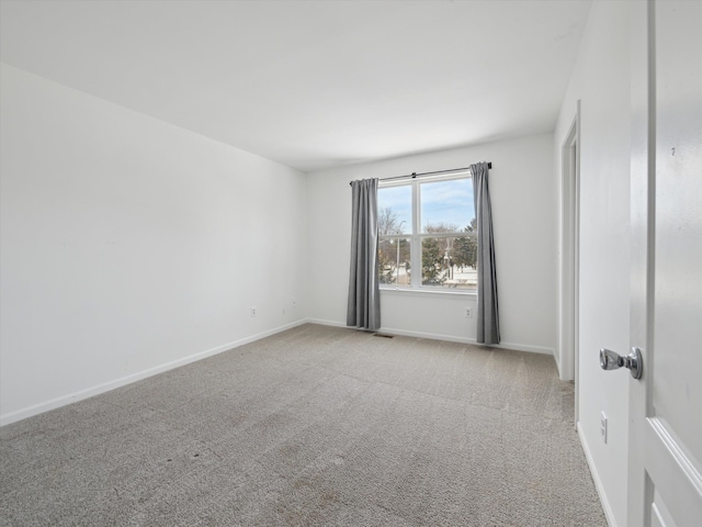 empty room featuring carpet floors and baseboards