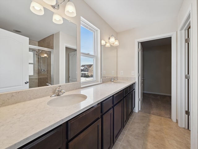 bathroom with double vanity, a stall shower, tile patterned flooring, and a sink