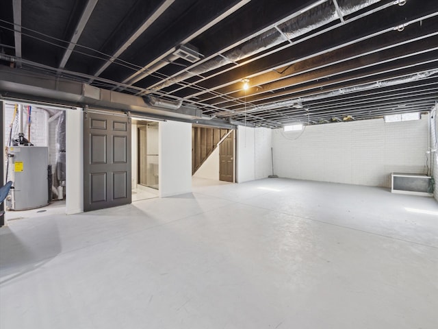 basement with electric water heater and brick wall