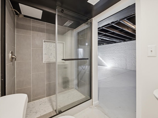 bathroom with a stall shower, brick wall, and toilet