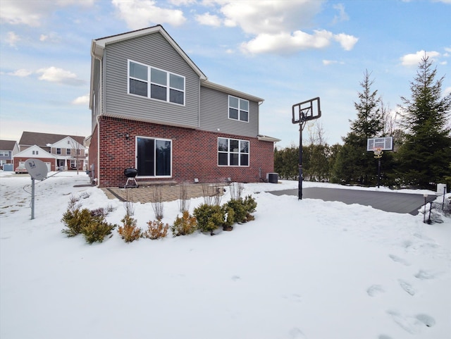 snow covered house with brick siding