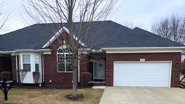 ranch-style house with a garage, brick siding, a shingled roof, concrete driveway, and a front yard