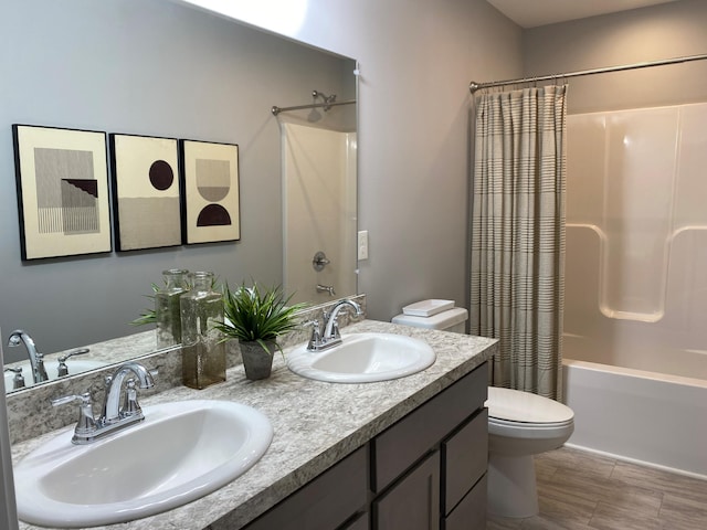 full bath featuring shower / bath combination with curtain, double vanity, a sink, and toilet