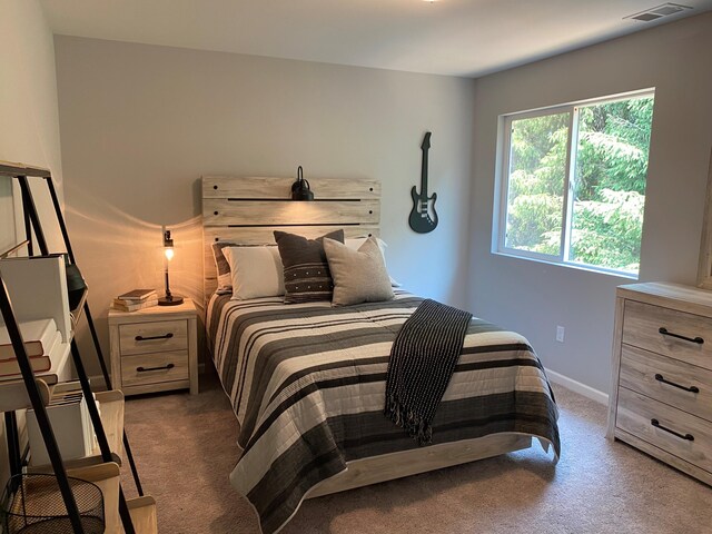 bedroom with dark carpet, visible vents, and baseboards