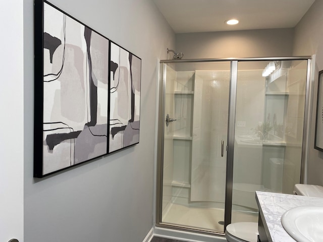 full bathroom with a stall shower, vanity, toilet, and recessed lighting