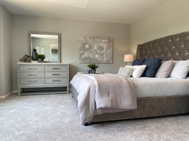 bedroom featuring light carpet and baseboards