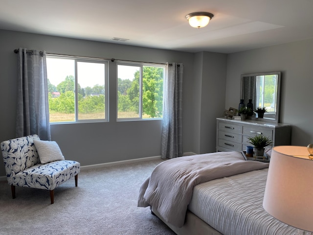 bedroom featuring carpet floors, multiple windows, visible vents, and baseboards