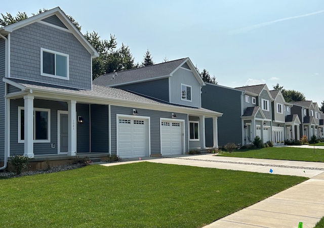 view of front of property featuring a garage, concrete driveway, covered porch, and a front lawn