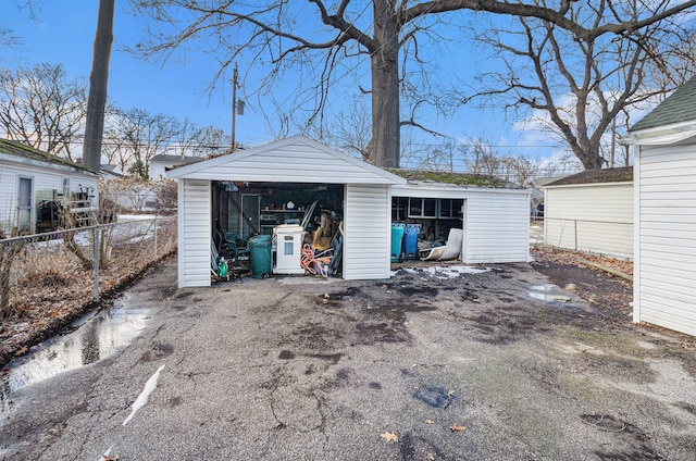 detached garage with a storage shed and fence