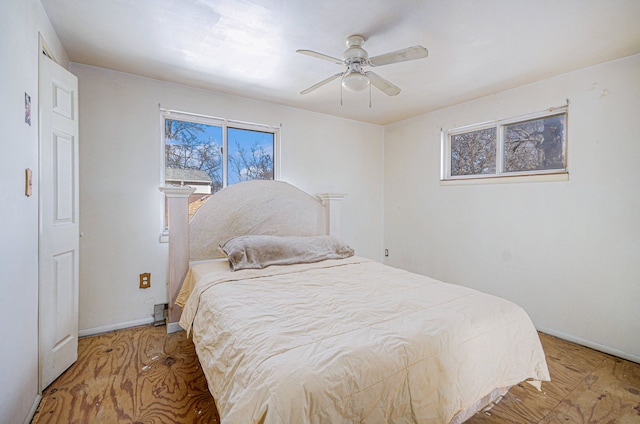 bedroom featuring ceiling fan, baseboards, and wood finished floors